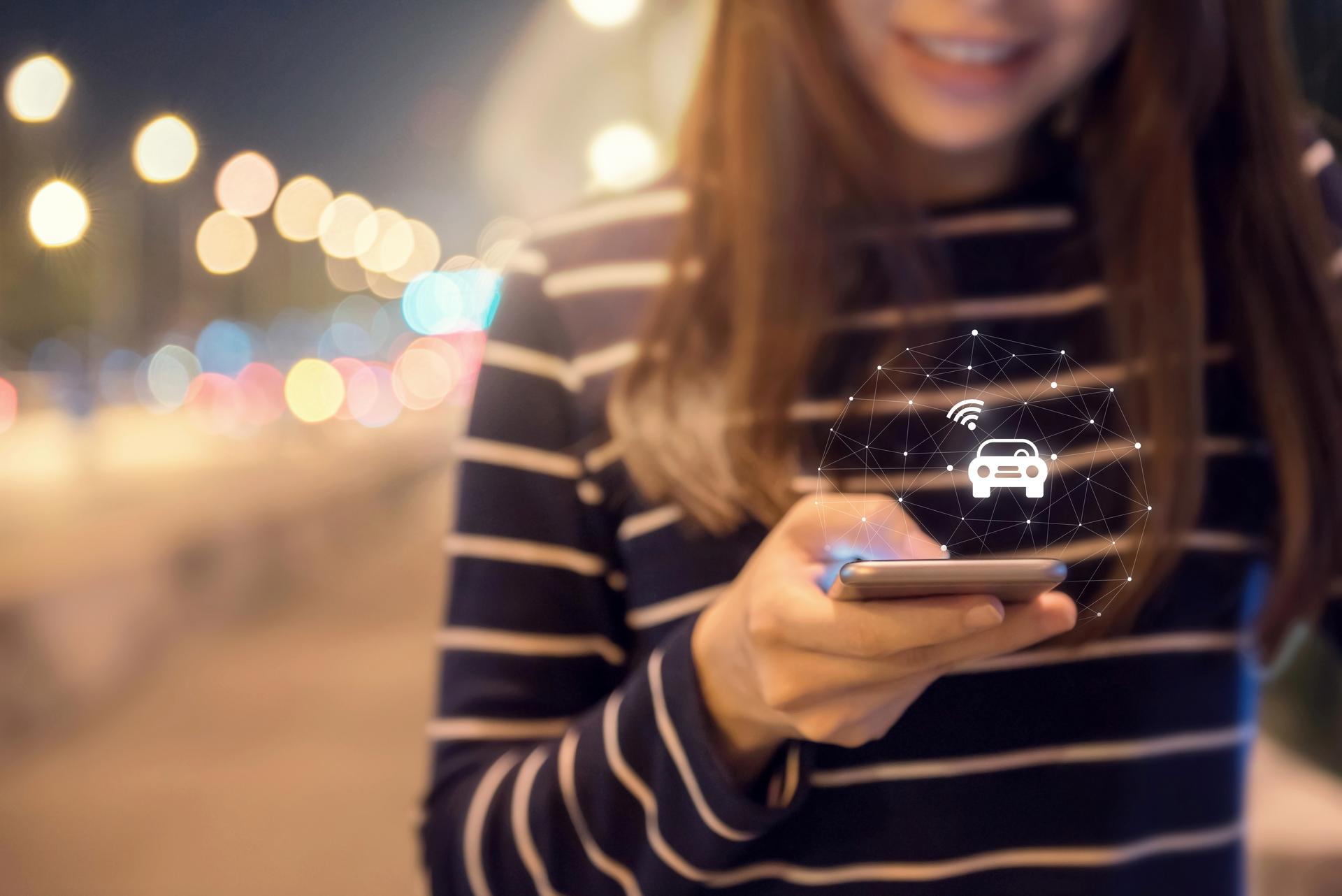 Close up woman hand orders a taxi from his mobile smartphone application.